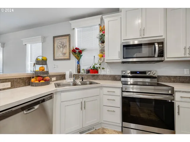 a kitchen with stainless steel appliances granite countertop a sink dishwasher stove and microwave