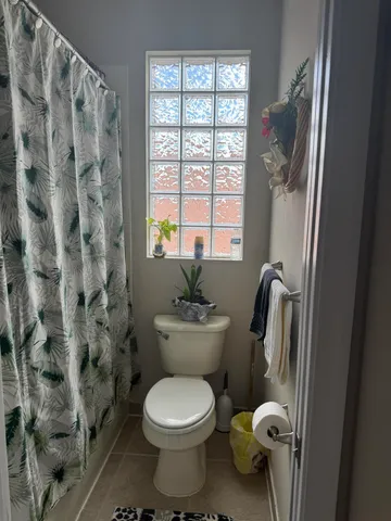 a bathroom with a toilet and a shower curtain