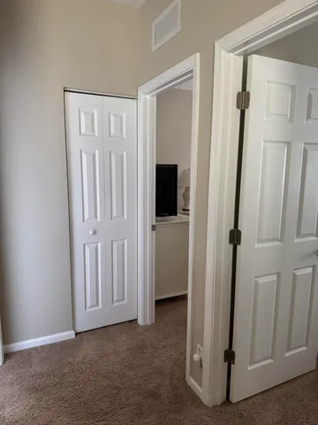 a view of a hallway with wooden floor and entryway