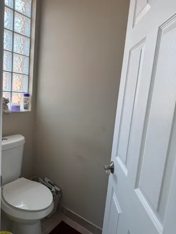 a white toilet sitting next to a window