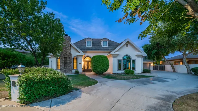 a front view of a house with a yard and potted plants