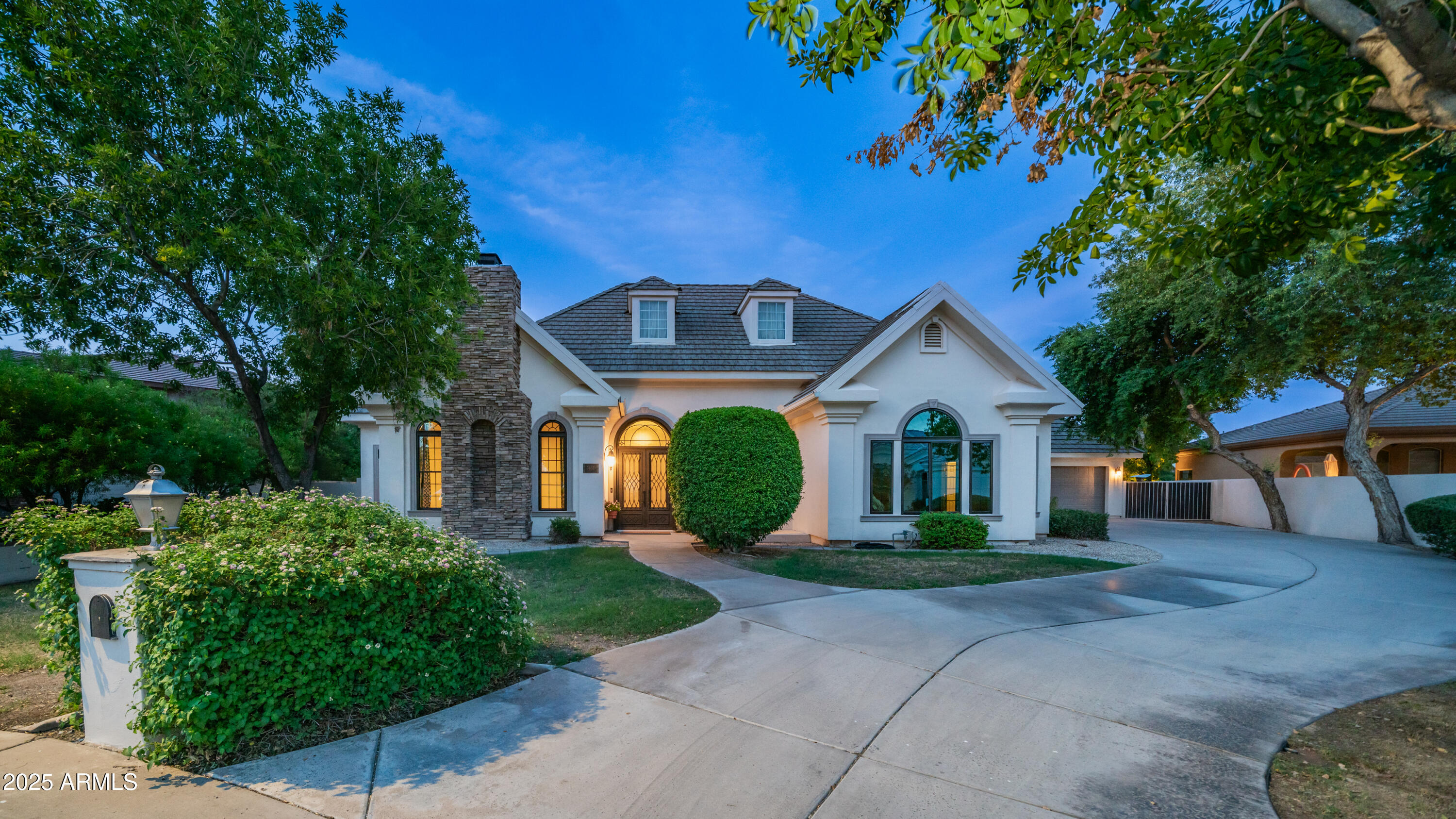a front view of a house with a yard and potted plants