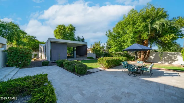 a view of a white house with a yard and potted plants
