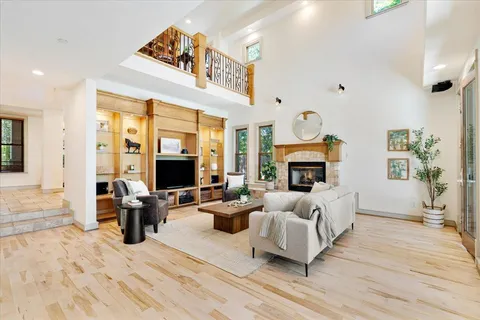 a living room with furniture large window and a fireplace