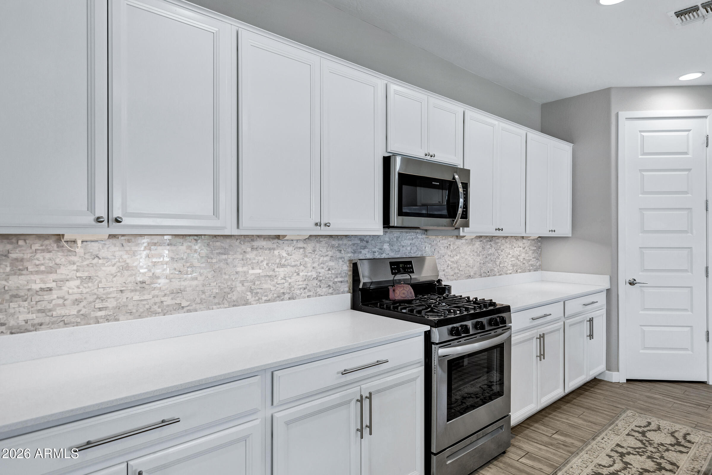 12243 East Sereno Road Gold Canyon, AZ 85118 - Photo 12 of 37 a kitchen with white cabinets and stainless steel appliances