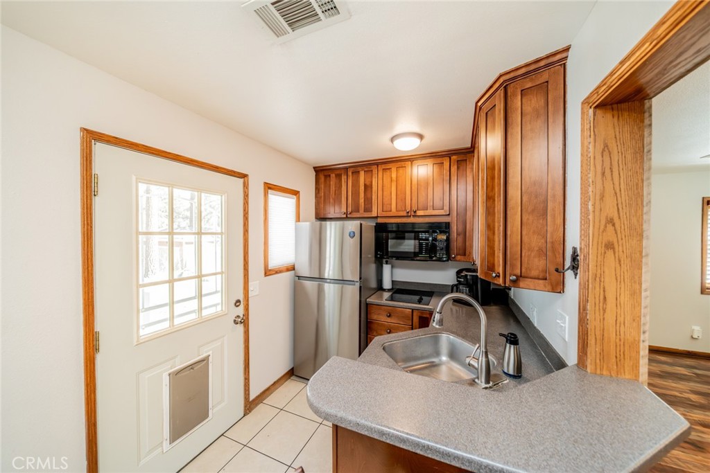1724 Thrush Road Wrightwood, CA 92397 - Photo 15 of 39 a kitchen with a refrigerator a stove and a sink with wooden floor