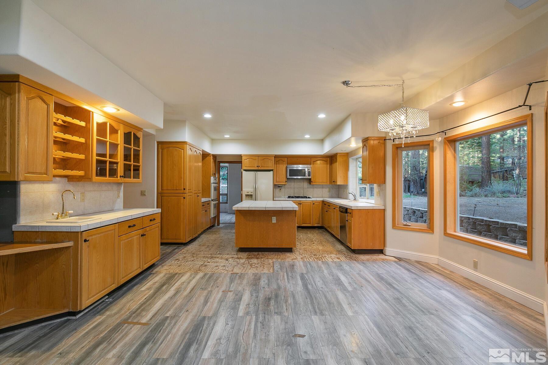 119 Meadow Drive Stateline, NV 89449 - Photo 14 of 30 a large kitchen with stainless steel appliances kitchen island a large counter top and a view of living room