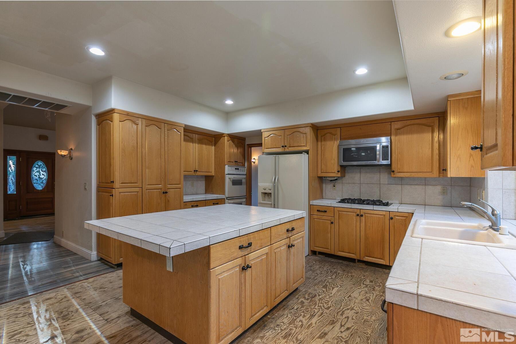 119 Meadow Drive Stateline, NV 89449 - Photo 15 of 30 a kitchen with stainless steel appliances granite countertop a sink stove and refrigerator