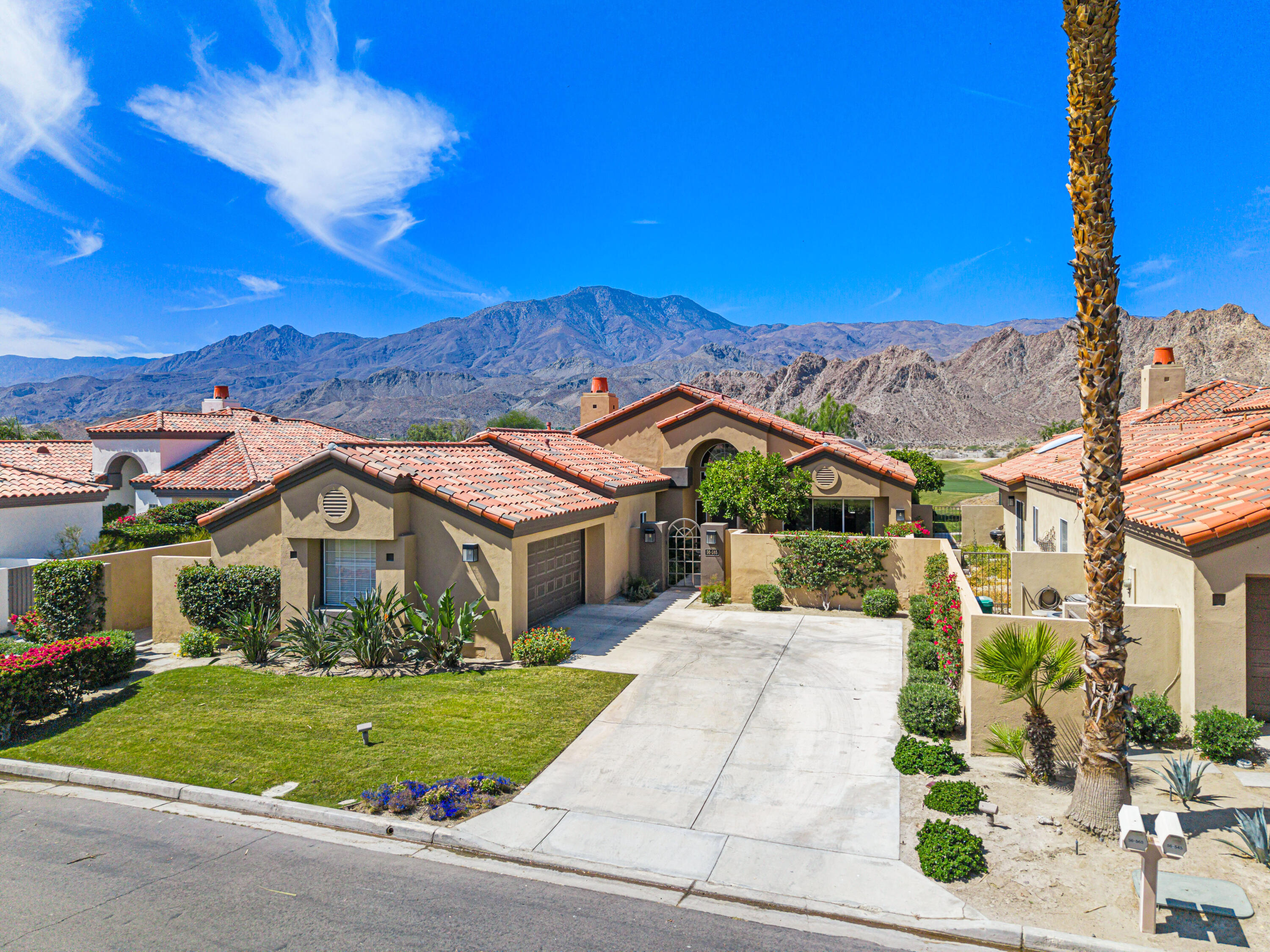 56565 Riviera La Quinta, CA 92253 - Photo 4 of 48 a front view of a house with a yard and garage