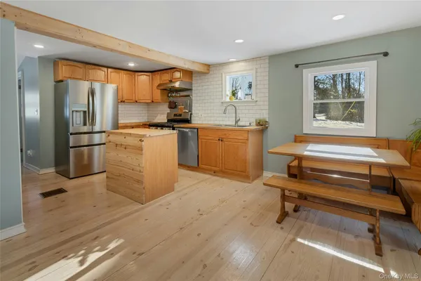 a kitchen with a refrigerator and wooden cabinets