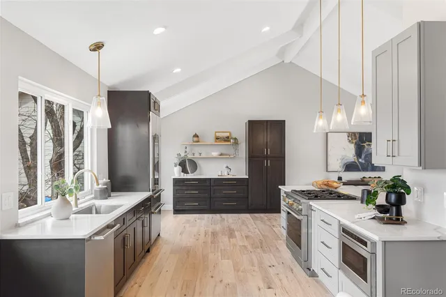 a kitchen with stainless steel appliances kitchen island granite countertop a sink stove and refrigerator