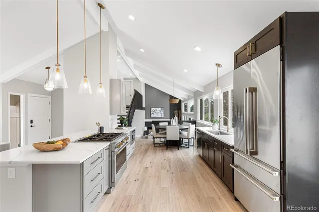 a kitchen with stainless steel appliances a stove a sink a refrigerator and cabinets