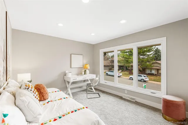 a bedroom with furniture and a large window
