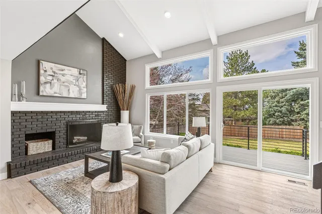 a living room with furniture large window and fireplace