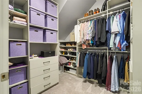 a view of walk in closet with clothes