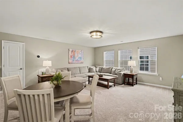 a living room with furniture stairs and a window