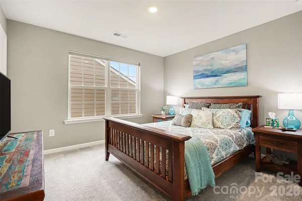 a bedroom with a bed a couch and a window