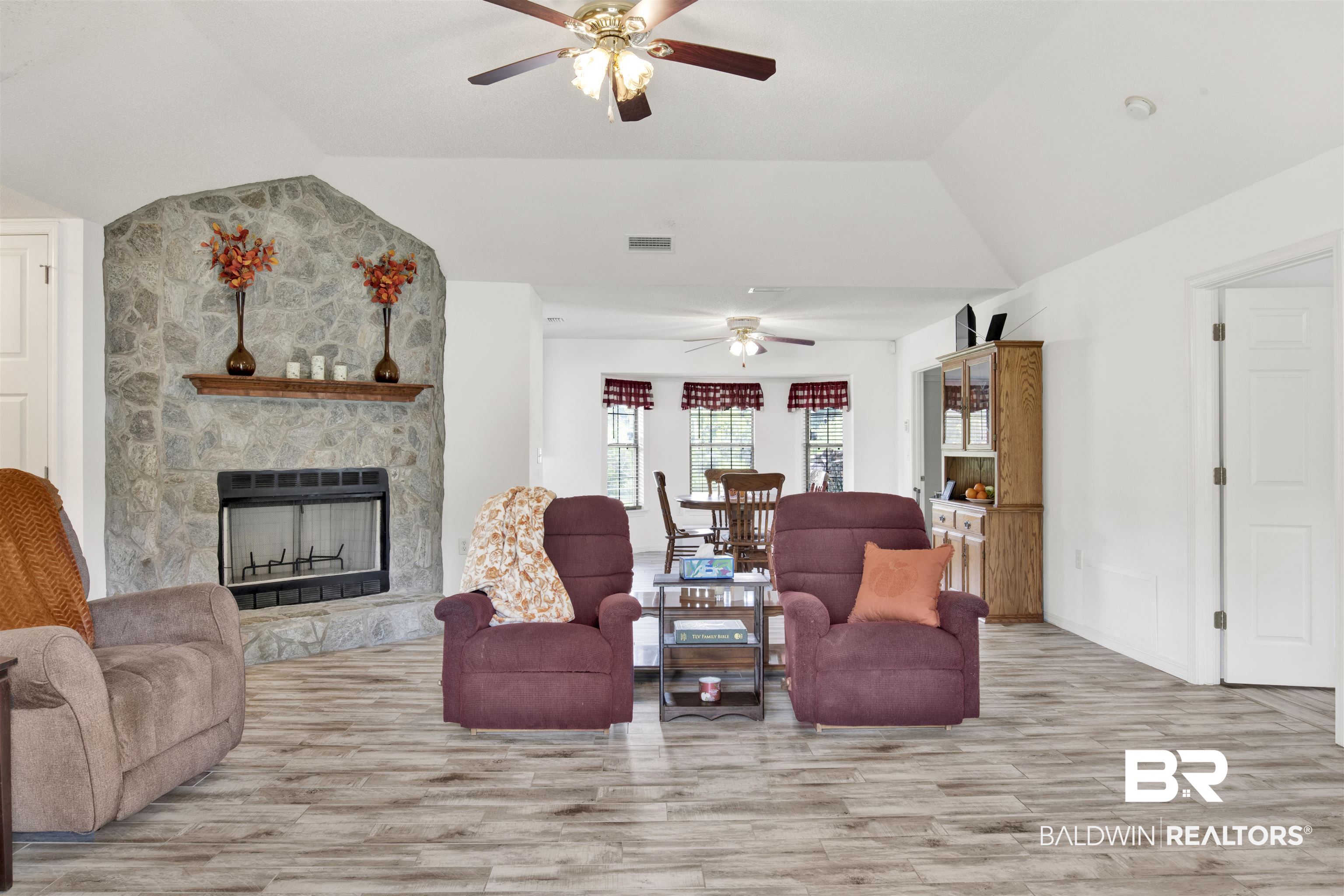 54563 Splinter Hill Road Perdido, AL 36562 - Photo 12 of 29 Living room with light hardwood / wood-style flooring, ceiling fan, a fireplace, and vaulted ceiling