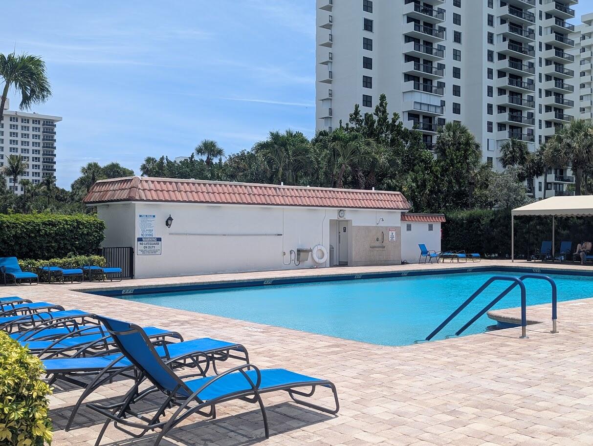 2121 North Ocean Boulevard, Unit 1006E Boca Raton, FL 33431 - Photo 53 of 64 a view of a swimming pool with a lounge chairs