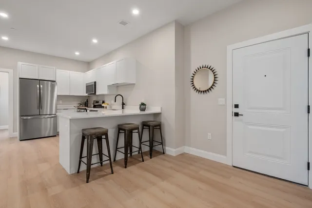a kitchen with stainless steel appliances a refrigerator sink and cabinets