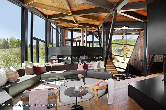 a living room with furniture fireplace and a large window