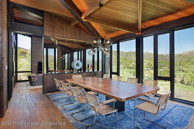 a dining room with wooden floor table and chairs