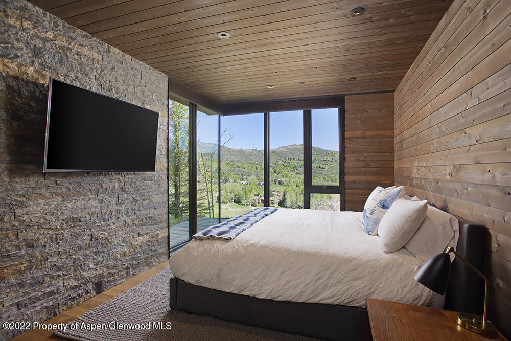 27 Turkey Trot Court Snowmass Village, CO 81615 - Photo 36 of 45 a bedroom with a bed and a flat screen tv