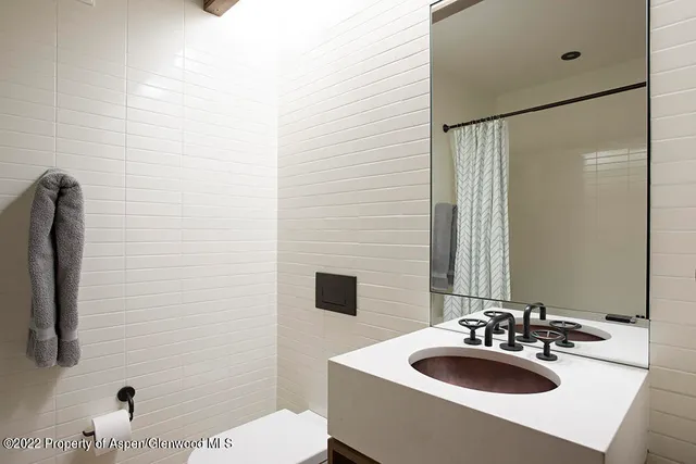 a bedroom with a bed a dresser next to a window