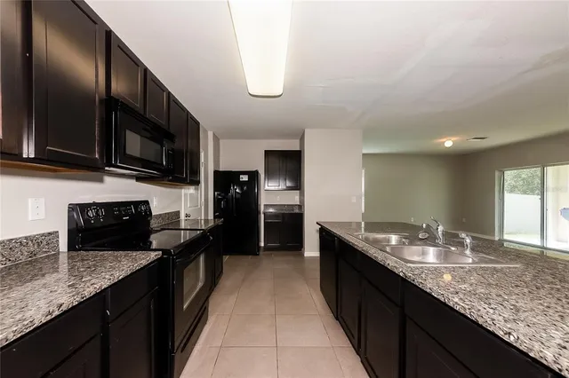 a large kitchen with granite countertop lots of counter space and a sink