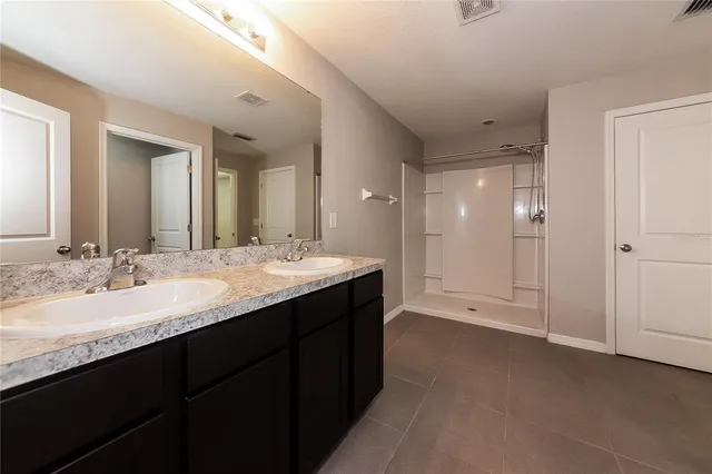 a bathroom with a double vanity sink and mirror