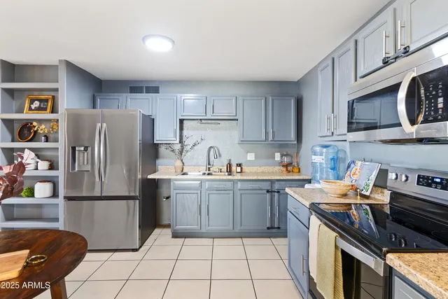 a kitchen with stainless steel appliances granite countertop a refrigerator stove top oven and sink