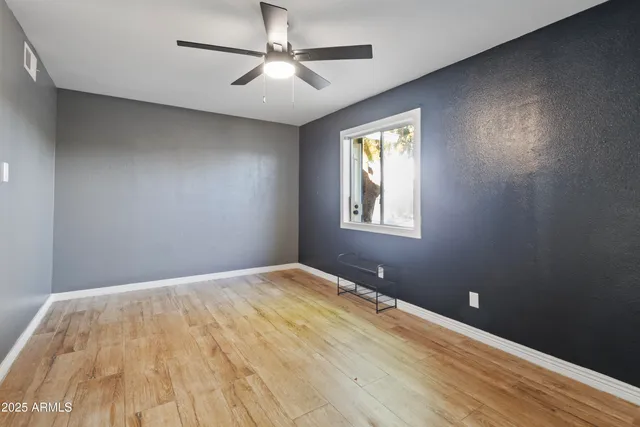 a view of empty room with wooden floor