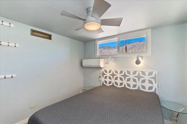 a bedroom with a bed and a large window