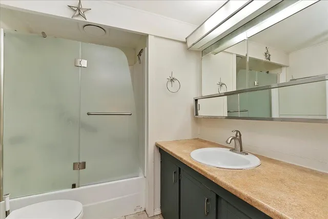 a view of a house with a small yard and wooden fence