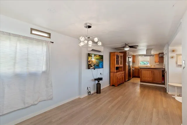a view of a room with wooden floor and kitchen