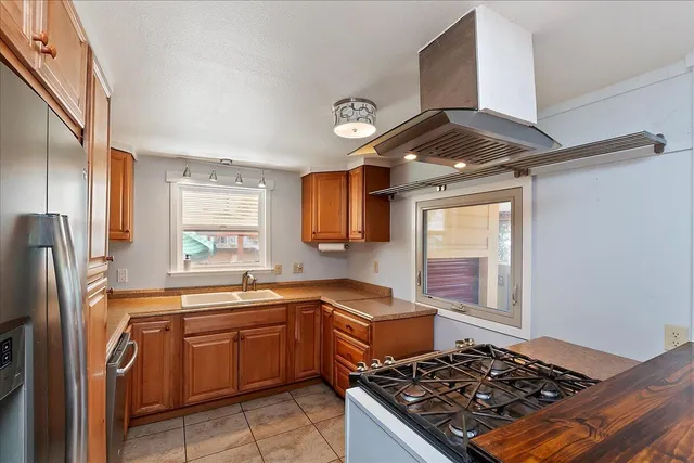 a kitchen with stainless steel appliances a sink stove and window