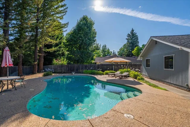a view of house with swimming pool yard and outdoor seating