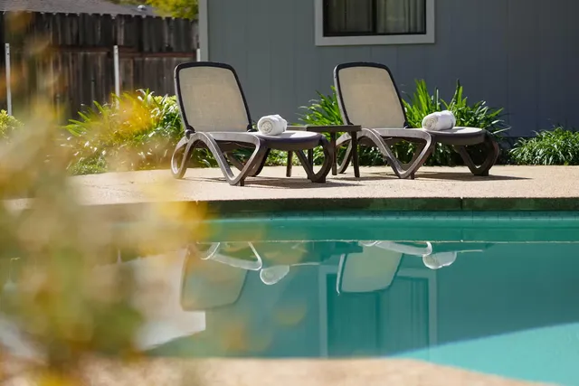 a front view of a house with swimming pool having outdoor seating