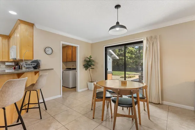 a view of a dining room with furniture a chandelier and wooden floor
