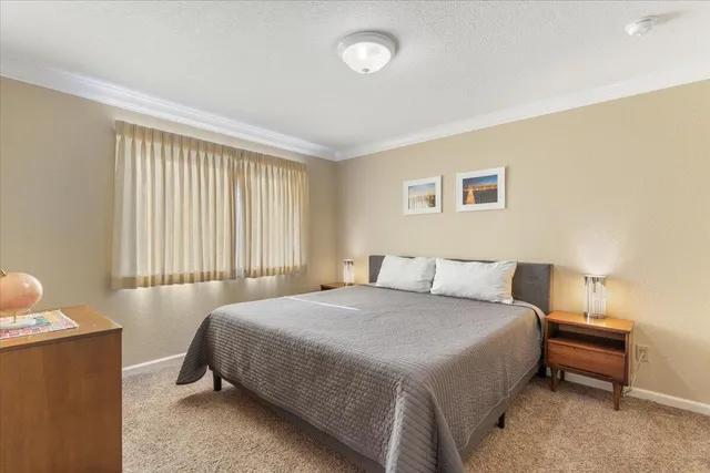 a bedroom with two beds and painting on the wall