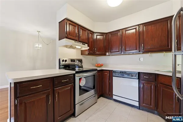 a kitchen with granite countertop wooden cabinets and white appliances