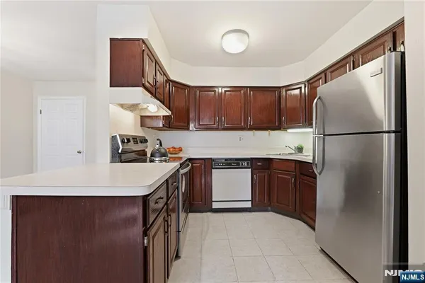 a kitchen with a refrigerator a stove top oven and a sink
