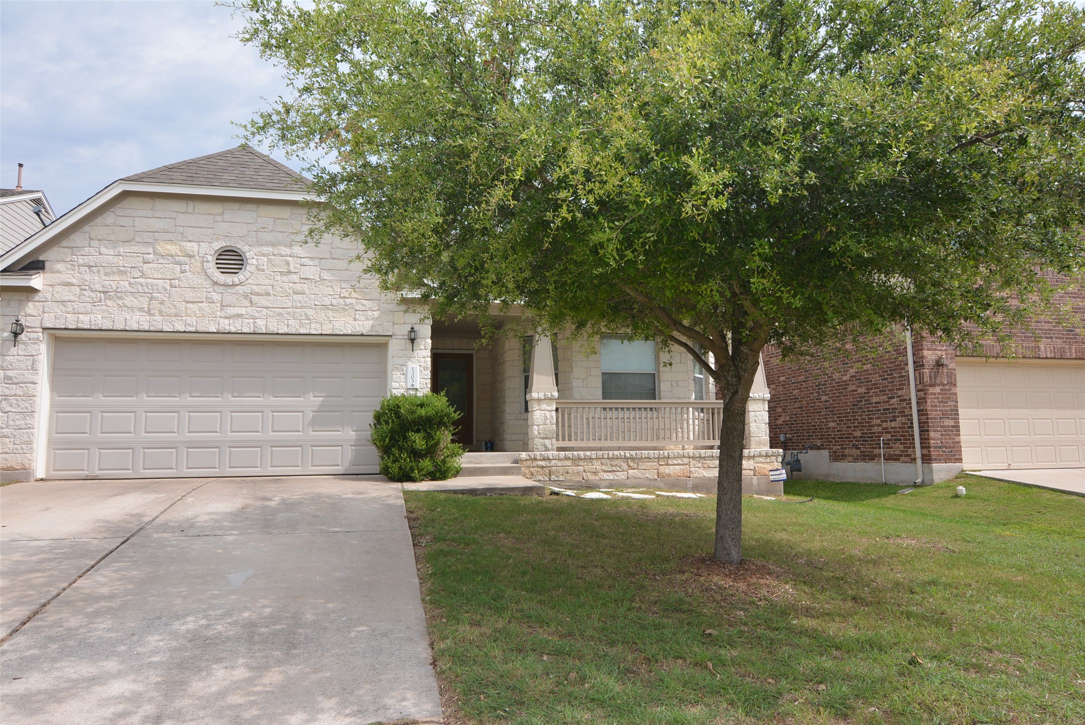 1303 Horseshoe Ranch Drive Leander, TX 78641 - Photo 3 of 26 A stone facade welcomes, featuring a generous garage and covered front porch, framed by mature trees.