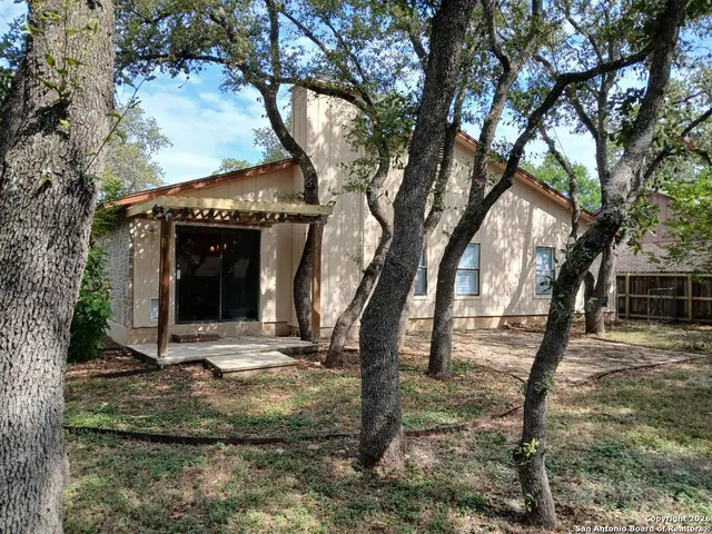 a backyard of a house with barbeque oven and table
