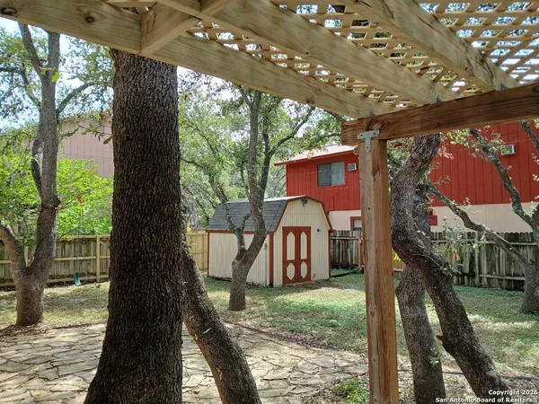 a view of a yard in front of a house with a large tree
