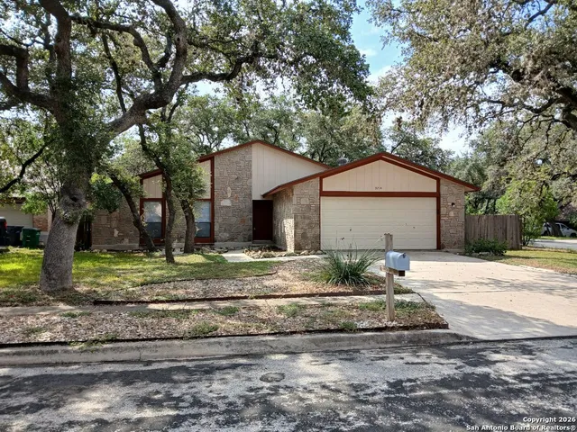 a front view of a house with a yard and trees