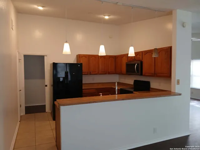 a kitchen with stainless steel appliances granite countertop a refrigerator and a stove
