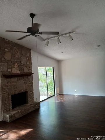 a view of empty room with wooden floor and fireplace
