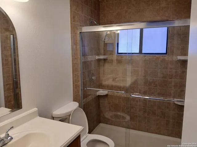 a bathroom with a toilet a sink and mirror