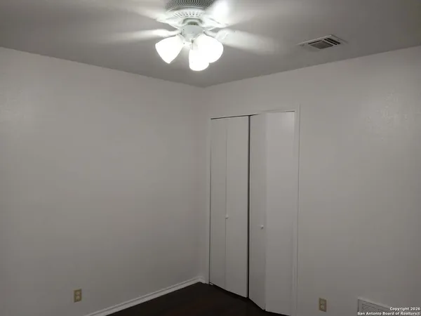 a view of a chandelier fan and hardwood floor